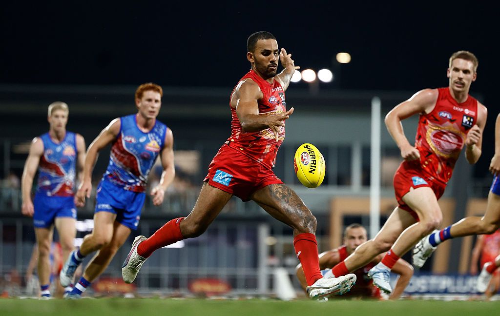 Touk Miller kicking the footy